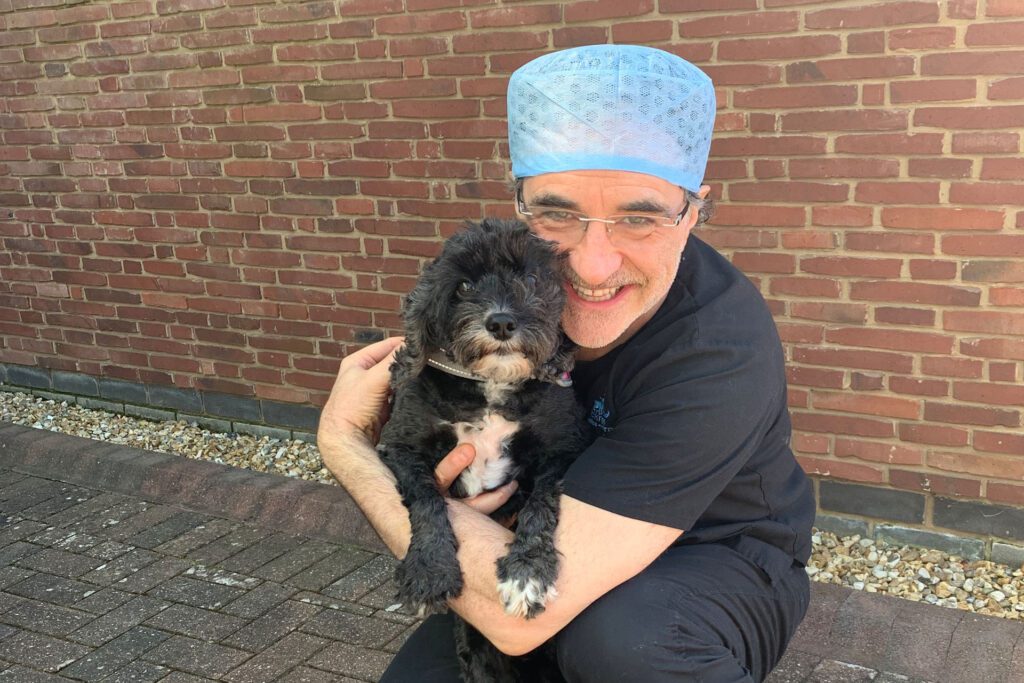 Professor Noel Fitzpatrick holding small black dog