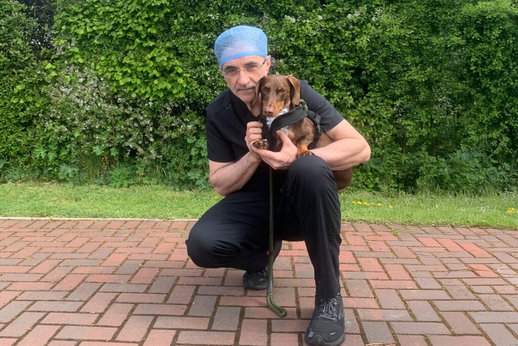 Supervet Professor Noel Fitzpatrick holding a dachshund patient