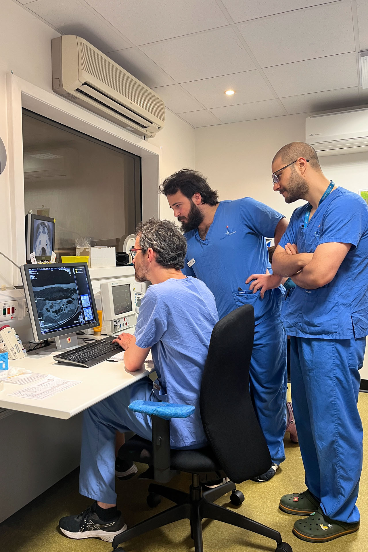Neurology specialist Marc Perez Soteras, with Interns Ed and Ozgur, looking at an MRI scan of a dog