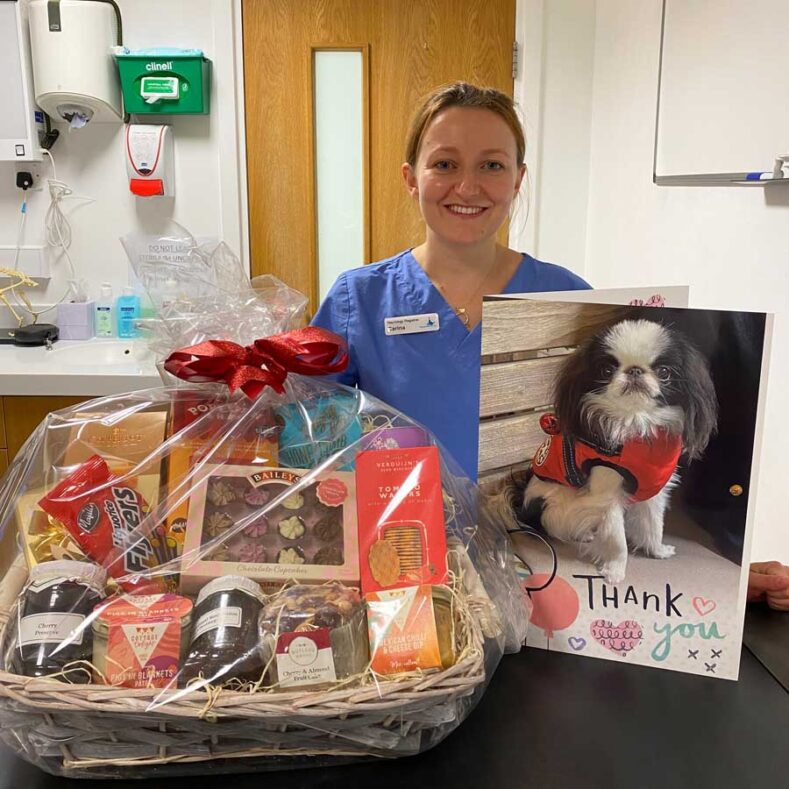 Vet pictured with a hamper of goodies and thank you card