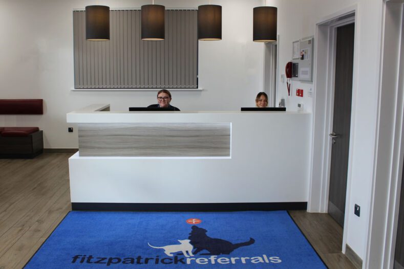 Two receptionists sitting behind a desk at Fitzpatrick Referrals