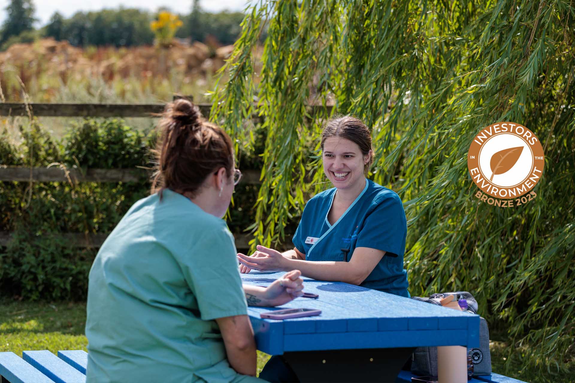 Veterinary staff sitting on recycled picnic bench