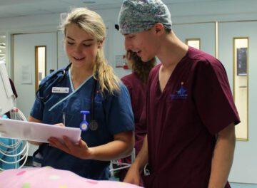 Veterinary nurse holding a clipboard standing over a patient